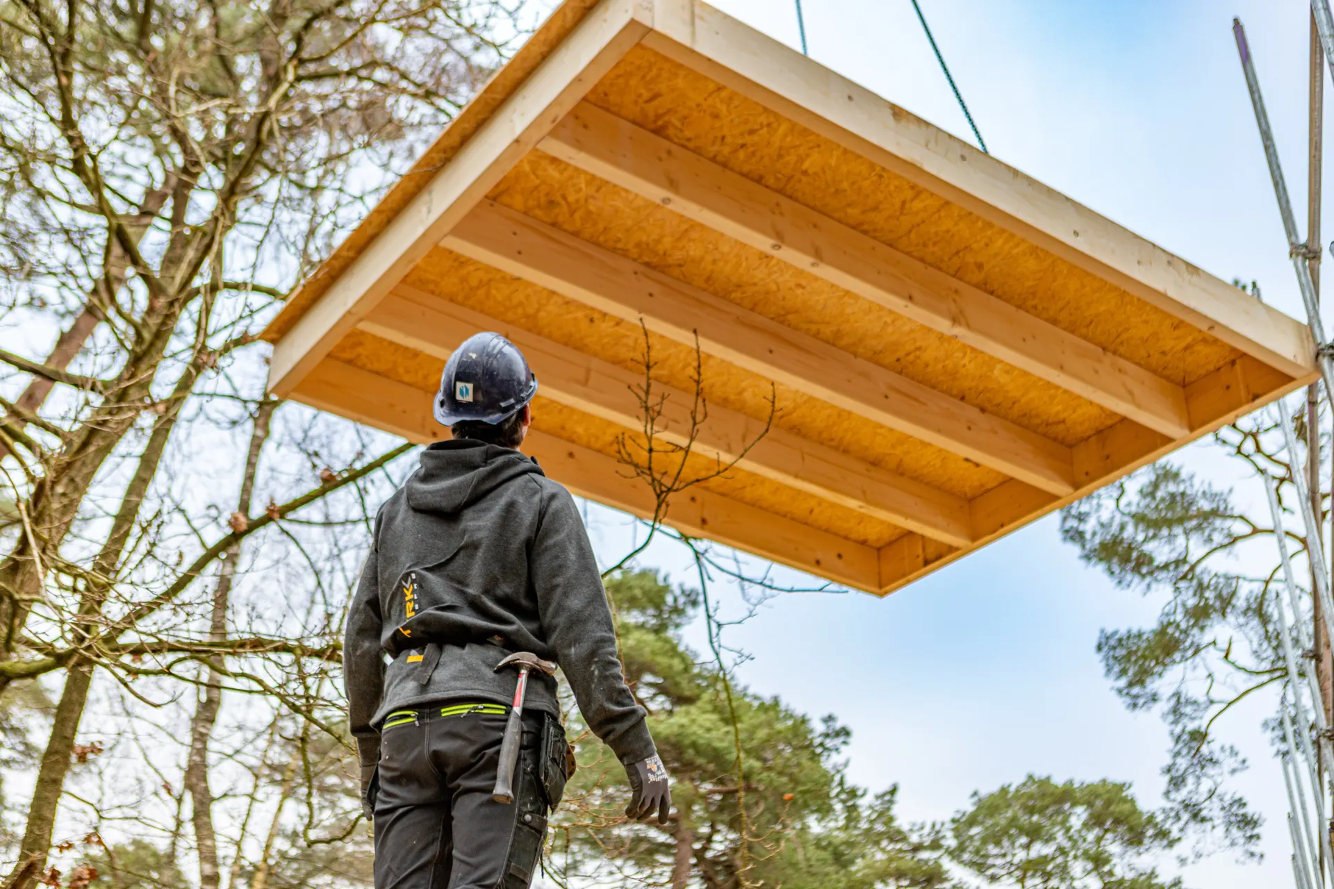 Prefab dakelement hangt aan de kraan boven een monteur