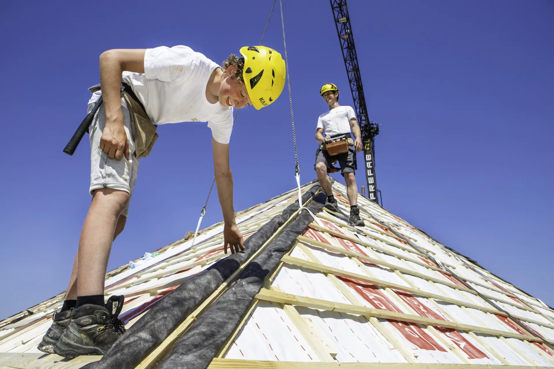 Twee monteurs van Sterkk Prefab werken op de nok van een prefab dak