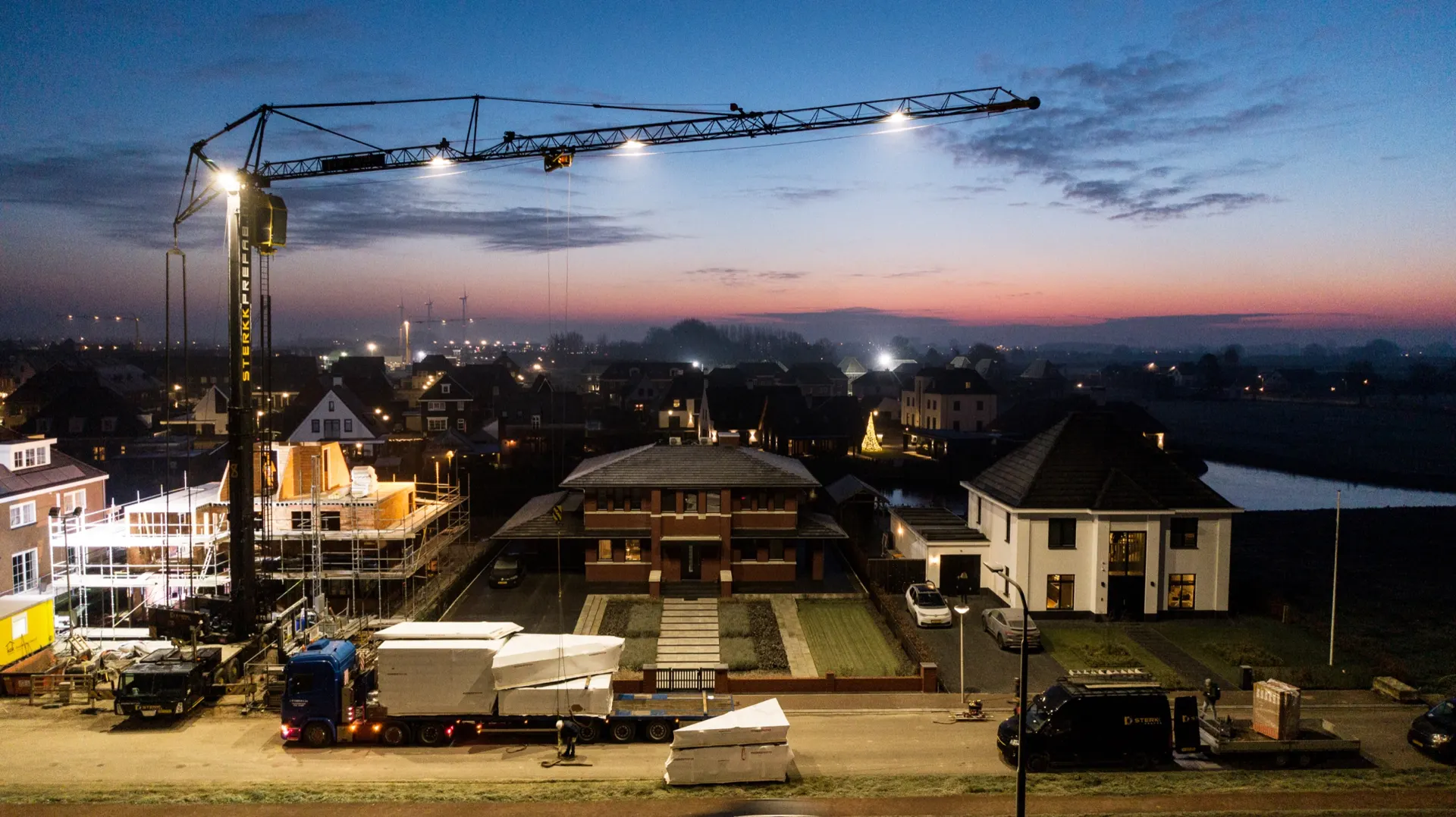 Kraan van Sterkk Prefab bij avond op een nieuwbouwproject in Meteren